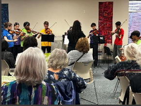 OrKidstra performs and volunteers are in audience