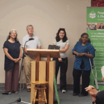 photo of the 3 learners who were in the new video standing at the front beside the tv that shows our new website. They are standing with 2 members from Character Creative, the company that did the website and video.